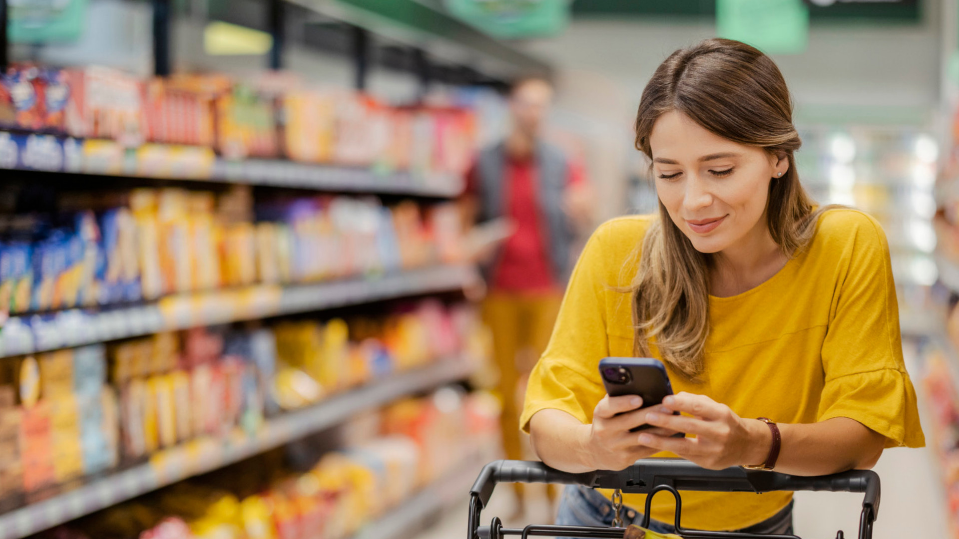 Foto: Frau mit Smartphone beim Einkauf im Supermarkt (Copyright: batten-company.com)